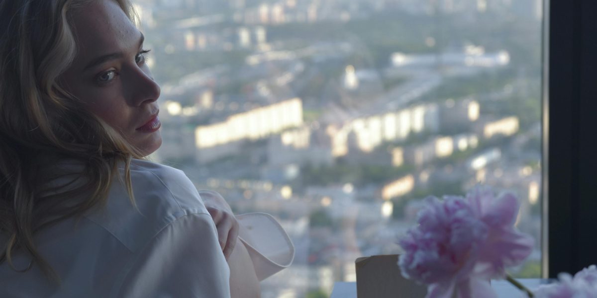 A person gazing at a modern city skyline, symbolizing aspirations for property ownership and long-term residency.