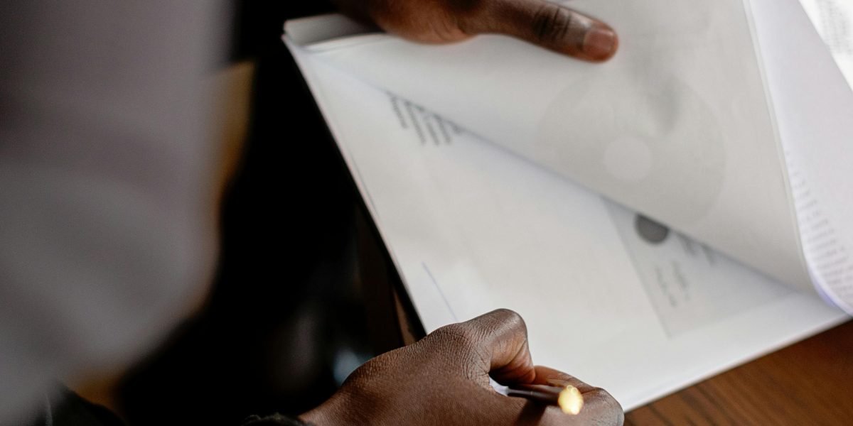An individual meticulously organizes their paperwork, ensuring a smooth banking and investment process.