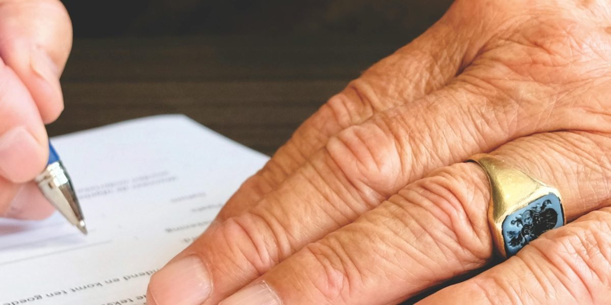 A person confidently signing a legal document, symbolizing the important step of securing a tenancy contract.