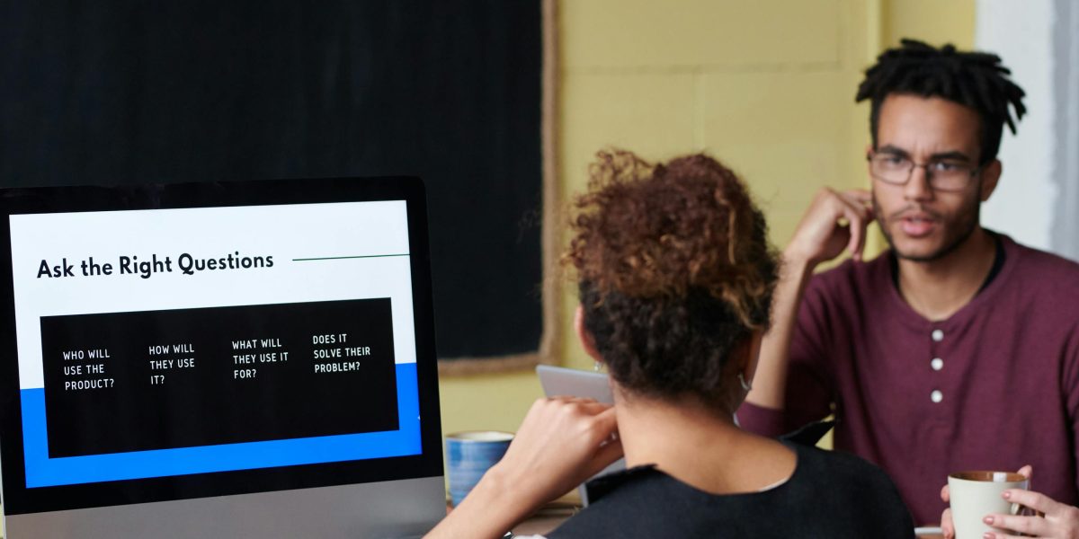 An individual actively engaging an advisor, asking critical questions during a vetting meeting.