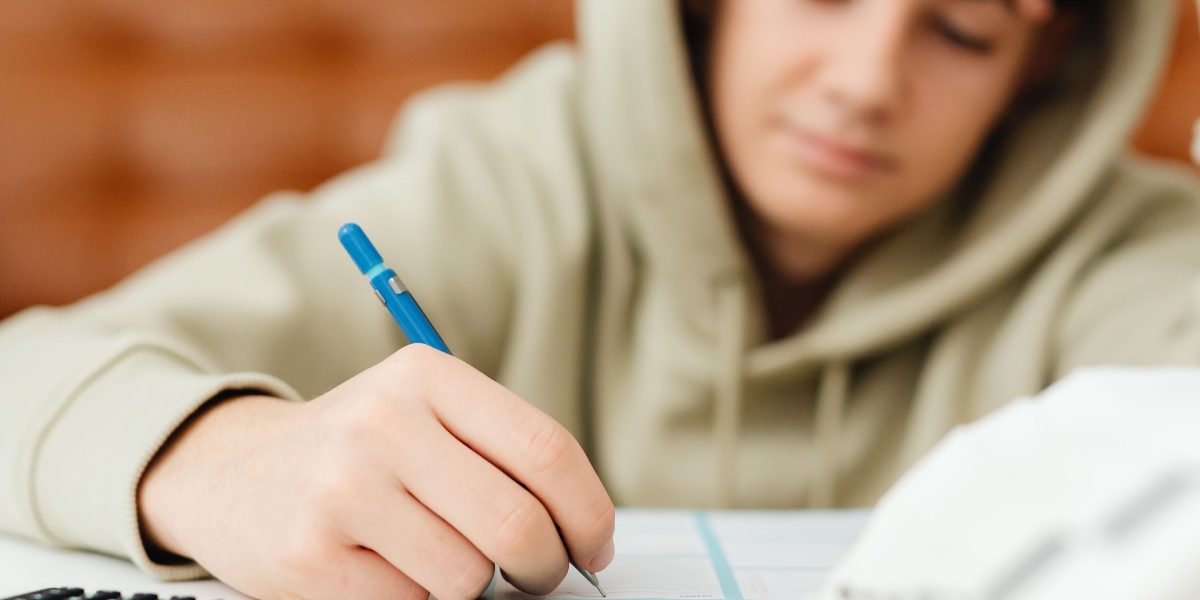 A person focused on studying, symbolizing the academic commitment required for financial advisor certifications and qualifications.