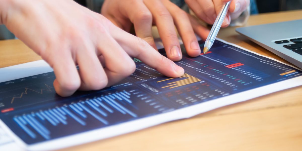 Two professionals engaging in a serious discussion, reviewing financial reports and projections.
