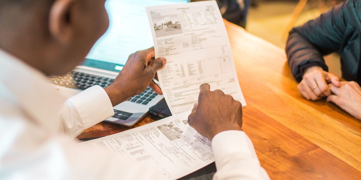 A financial advisor guiding a client through complex cross-border transactions for property purchases.
