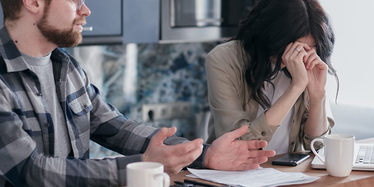 A couple thoughtfully discussing financial plans and future home options, reflecting the decision-making process for rent-to-own.