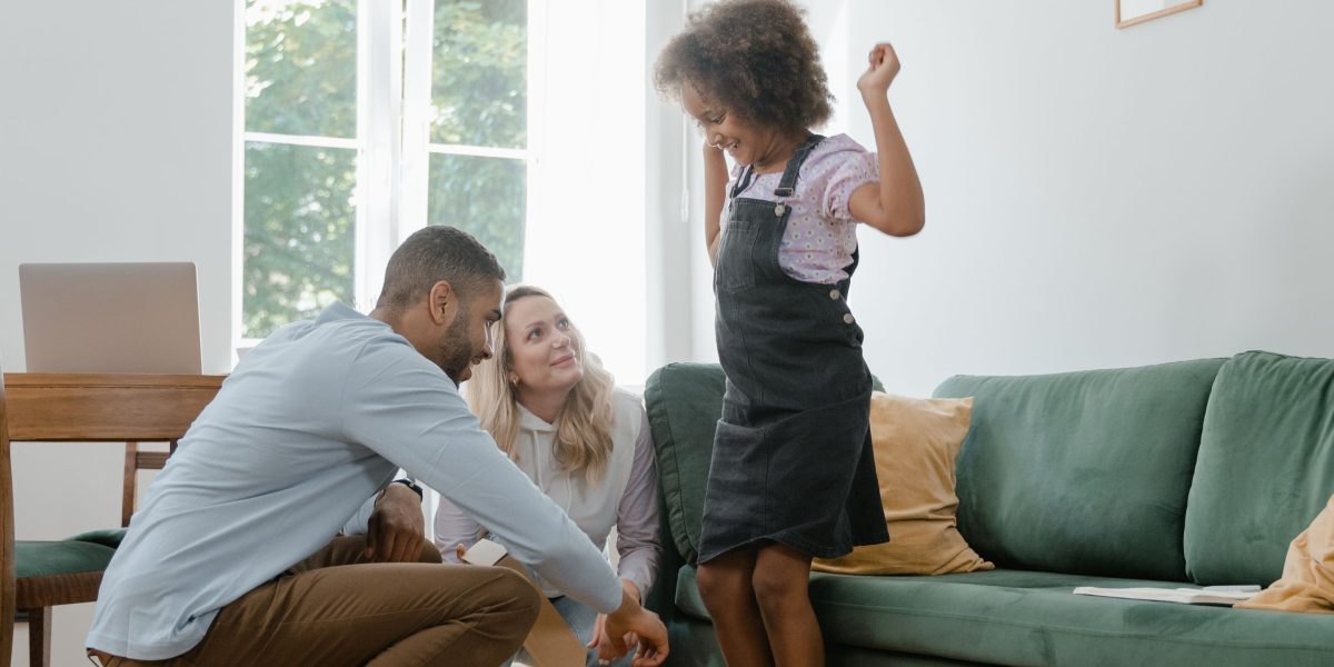 A happy family relaxing in a bright, modern living room, symbolizing the successful outcome of securing a home through rent-to-own.