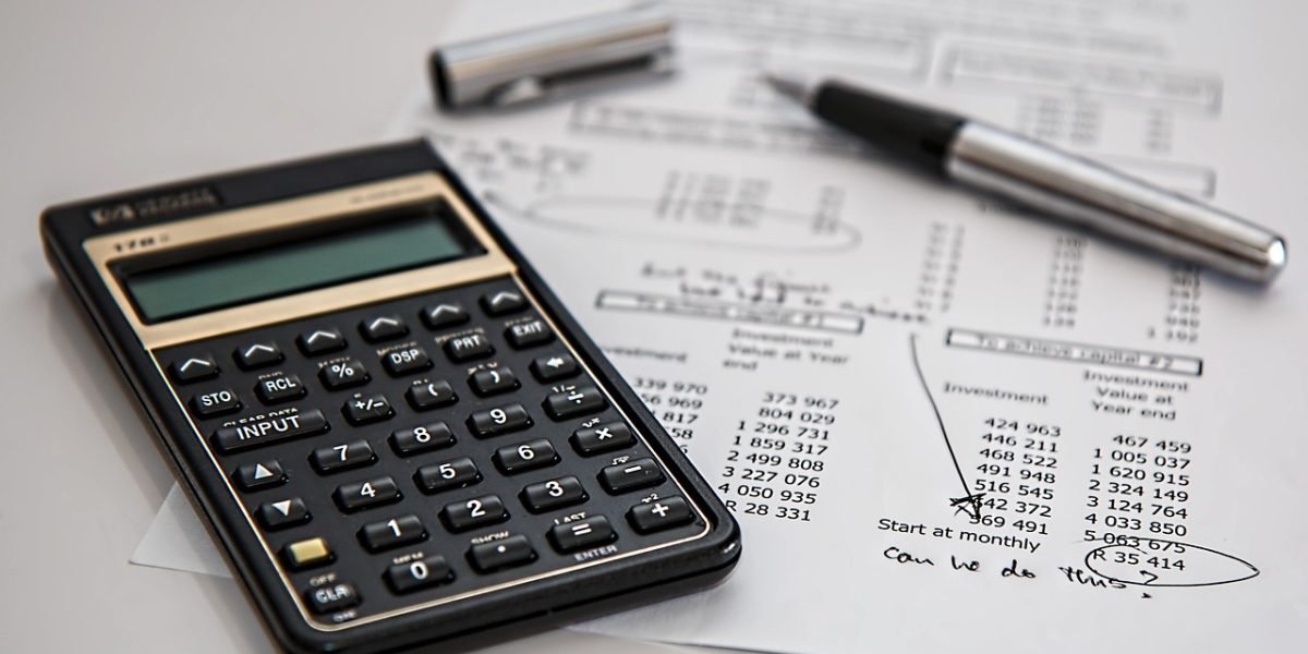 A person carefully reviews financial documents, symbolizing the need for diligent planning in property investment.