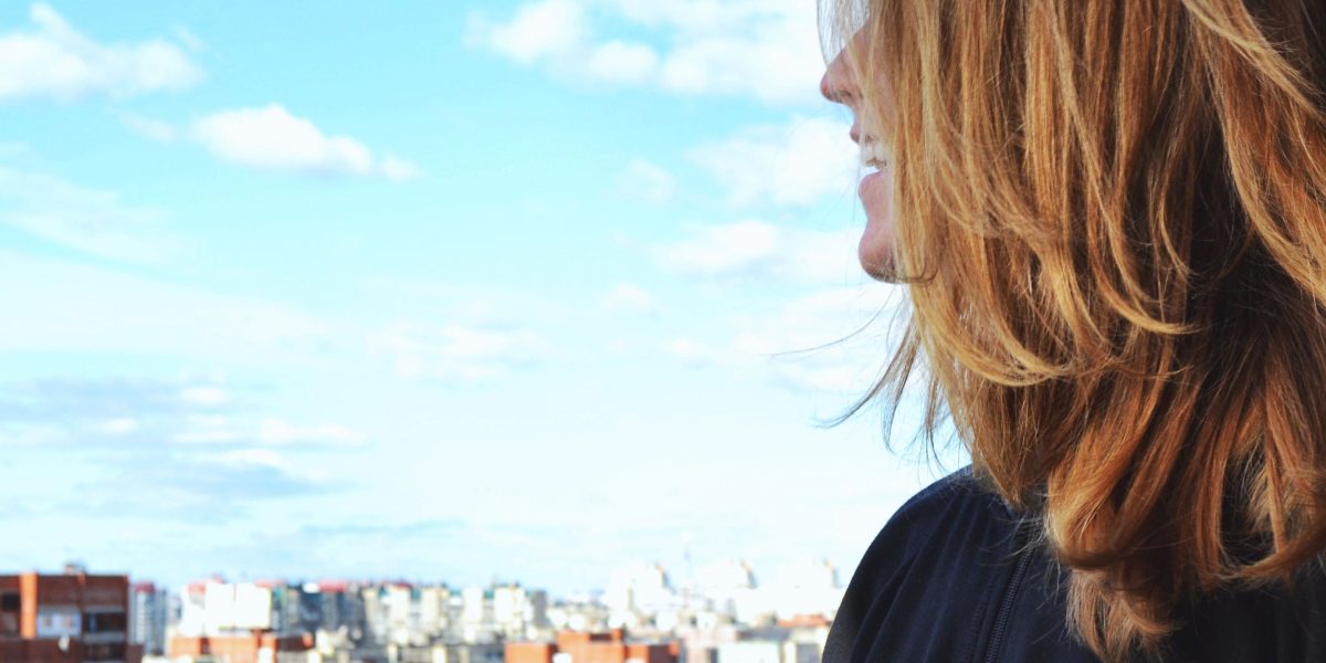 A person looking towards a futuristic city skyline, representing optimism for urban development.