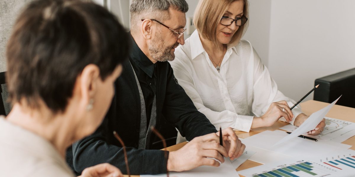 A financial advisor and client engage in a focused discussion, reviewing financial documents and planning strategies.