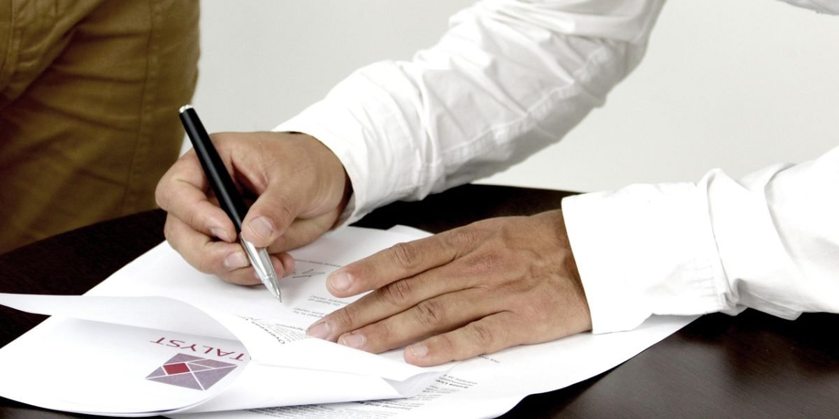 A person thoughtfully reviewing documents, symbolizing the complexity of financial regulations and the need for expert guidance.