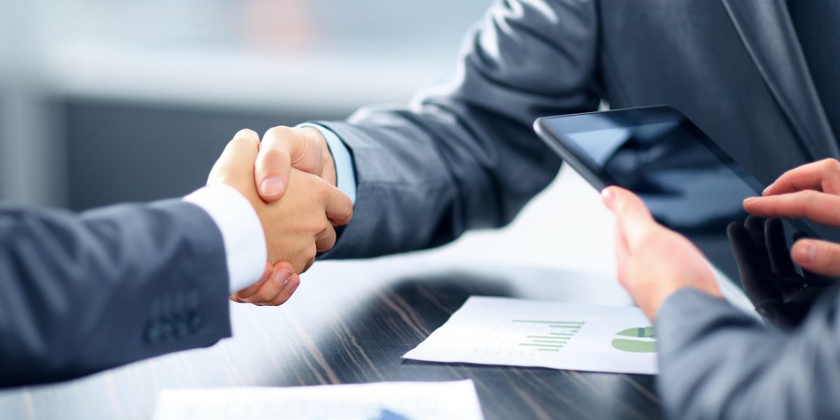 Two professionals shaking hands in a business setting, symbolizing trust and agreement after a successful meeting or consultation.