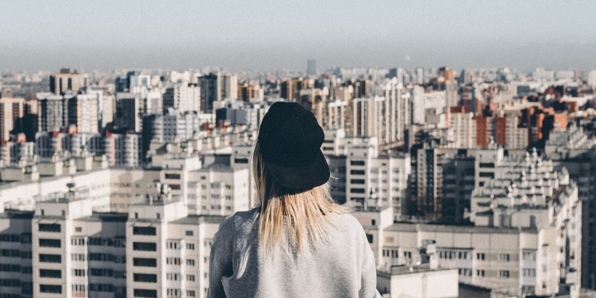 A person looking out at the vibrant, growing cityscape of Dubai, reflecting on new opportunities.