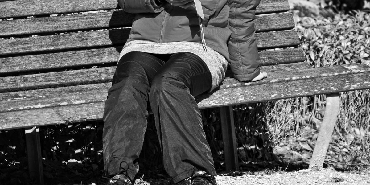 A person looking happy while checking their phone, representing the satisfaction of successful international money transfers or financial updates.