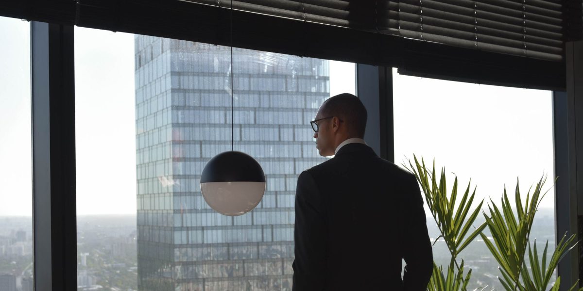An individual thoughtfully considering their financial goals and future investments amidst complex international financial landscapes.
