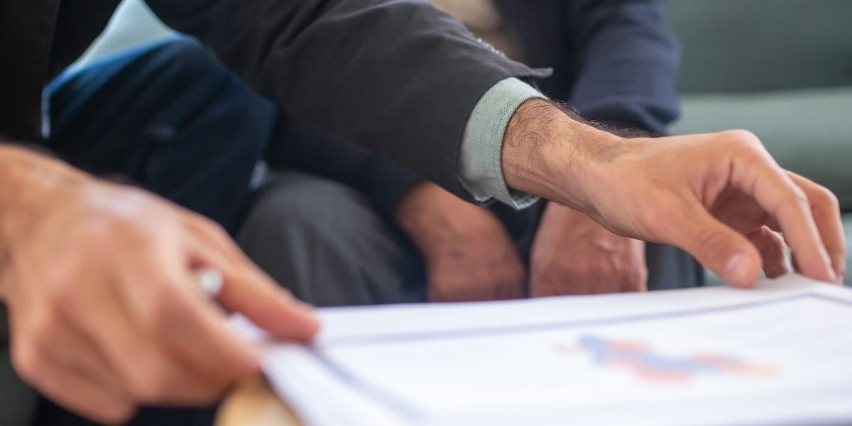 A professional financial advisor discussing comprehensive plans and strategies with a client in an office setting.
