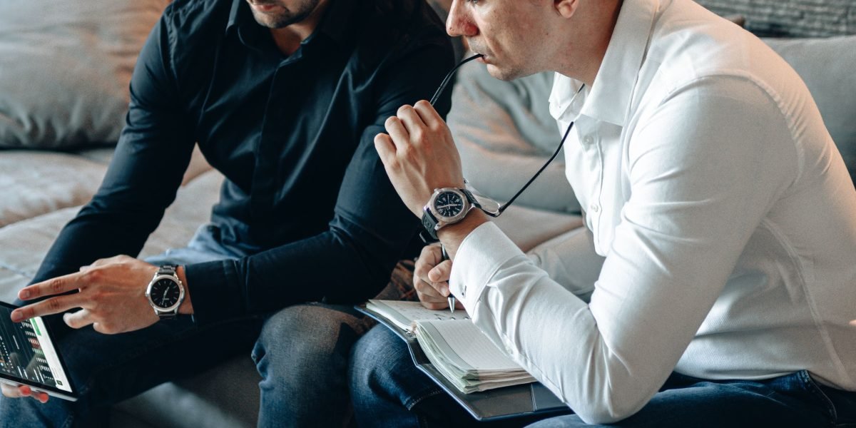Two professionals engaged in a serious discussion about potential investment opportunities, reflecting the article's focus on luxury investors.