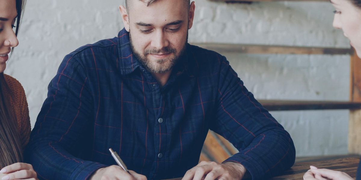 An expat thoughtfully reviewing documents related to property investment or financial planning.